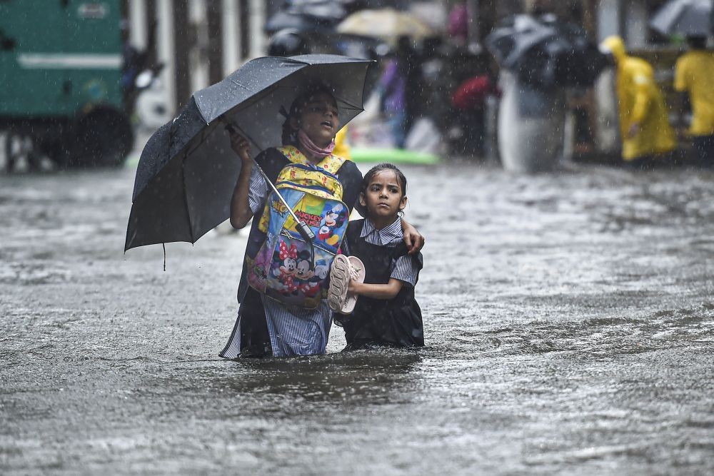 Mumbai: A school girl with her guardian wades through a flooded street following heavy monsoon rains, in Mumbai, Tuesday, July 5, 2022. (PTI Photo/Kunal Patil)