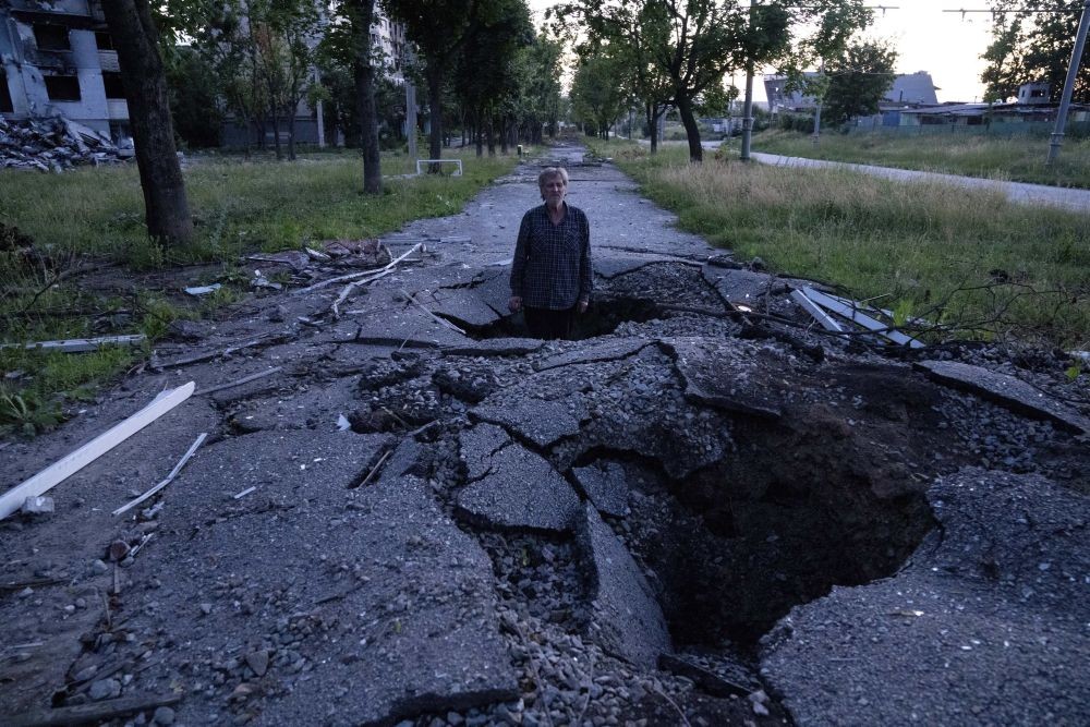 Viktor Shevchenko stands in a crater to show how deep it was that created by a shell after a Russian attack in the Saltivka district in Kharkiv, Ukraine, Friday, July 1, 2022.AP/PTI(A