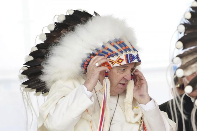 Pope Francis adjusts a traditional headdress he was given after his apology to Indigenous people for the church's role in residential schools during a ceremony in Maskwacis, Alberta, as part of his papal visit across Canada on Monday, July 25, 2022. (AP Photo)