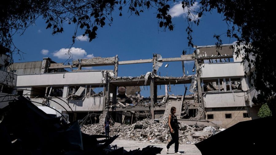 Ukrainian journalists walk in the yard of National Pedagogic university destroyed by a Russian attack in Kharkiv, Ukraine, Wednesday, July 6, 2022. (AP Photo/Evgeniy Maloletka)