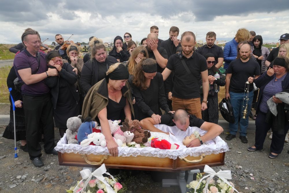 Relatives and friends attend the funeral ceremony for Liza, 4-year-old girl killed by Russian attack, in Vinnytsia, Ukraine, Sunday, July 17, 2022. Wearing a blue denim jacket with flowers, Liza was among 23 people killed, including two boys aged 7 and 8, in Thursday's missile strike in Vinnytsia. Her mother, Iryna Dmytrieva, was among the scores injured. AP Photo/PTI