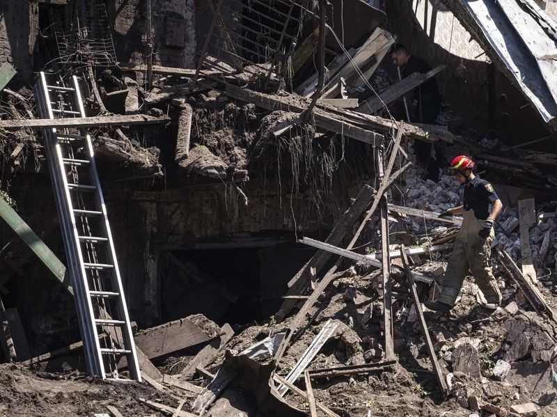 Rescue worker and police officer inspect a site of destroyed house after a Russian attack in a residential neighbourhood in downtown Kharkiv, Ukraine, on Saturday, July 9, 2022. Evgeniy Maloletka/AP