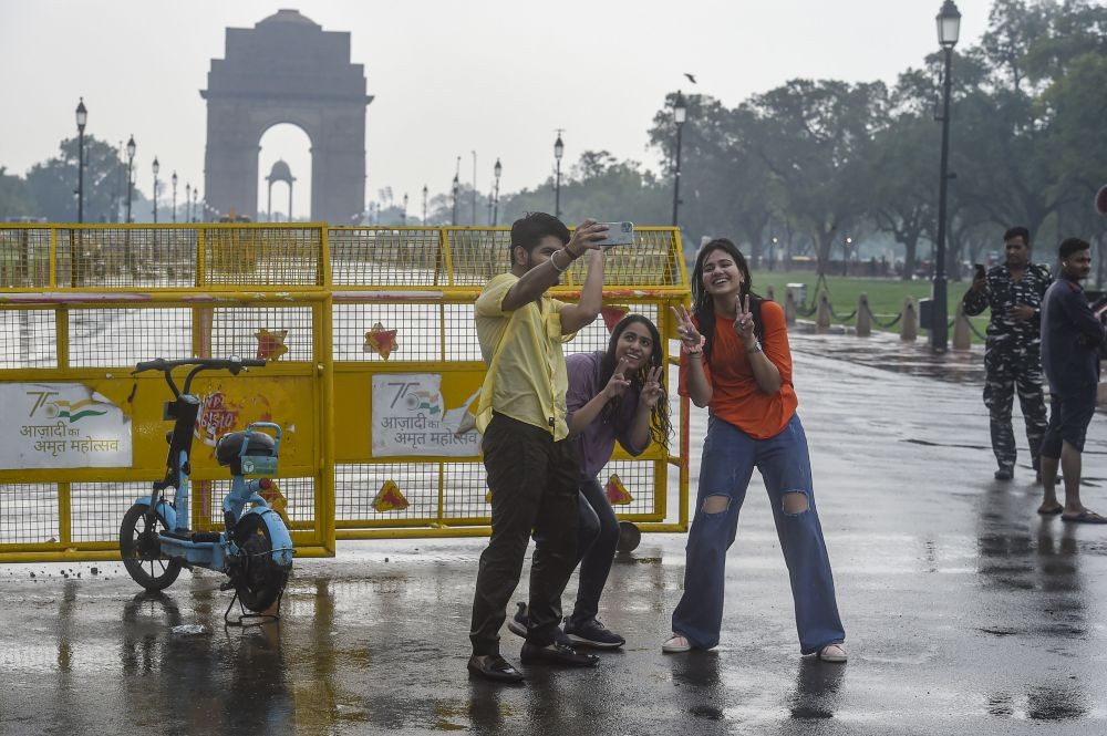New Delhi: Youngsters take a selfie during monsoon rain, near India Gate in New Delhi, Monday, July 11, 2022. (PTI Photo/Arun Sharma)