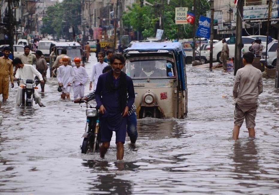 People wade through flood water after heavy rains in southern Pakistan's Hyderabad on Aug. 23, 2022. As many as 903 people were killed, nearly 1,300 injured and thousands left homeless as heavy monsoon rains and flash floods continued to play havoc in Pakistan since mid-June, the National Disaster Management Authority (NDMA) said on Wednesday. (Str/Xinhua)