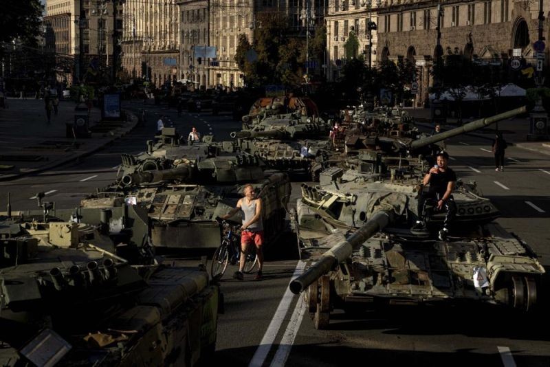 People walk around destroyed Russian military vehicles installed in downtown Kyiv, Ukraine, Wednesday, Aug. 24, 2022. Kyiv authorities have banned mass gatherings in the capital through Thursday for fear of Russian missile attacks. Independence Day, like the six-month mark in the war, falls on Wednesday. (AP Photo)