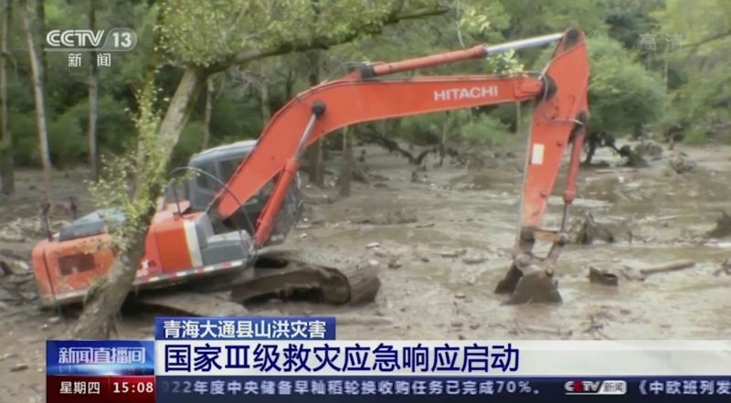 In this image taken from video footage run by China's CCTV, an excavator tries to clear mud from an area in the aftermath of flooding in Datong county in western China's Qinghai province on August 18, 2022. Some people died and others were missing after a sudden rainstorm in western China triggered a landslide that diverted a river and caused flash flooding in populated areas, Chinese state media said Thursday. Chinese characters on screen reads "National level 3 disaster relief activated." (CCTV via AP/PTI Photo)