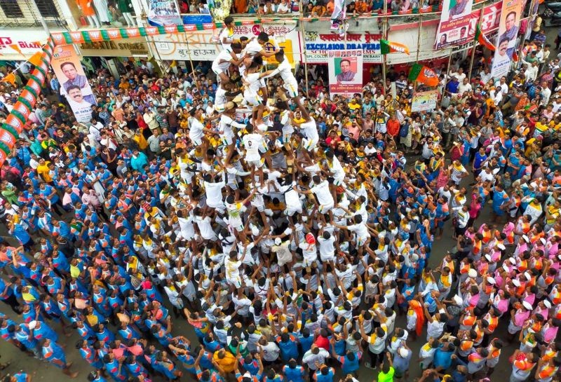 Devotees form a human pyramid to break 'dahi-handi', an earthen pot filled with curd suspended in the air, during the celebrations of the 'Janmashtami' festival at Dadar, in Mumbai on August 19, 2022. (PTI Photo)