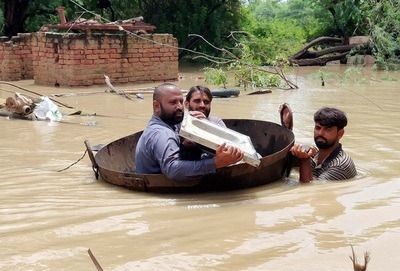 Pakistan : Residents cross a flooded area in a makeshift boat amid floods caused by heavy downpours. (Photo: -/PPI via ZUMA Press Wire/dpa/IANS)