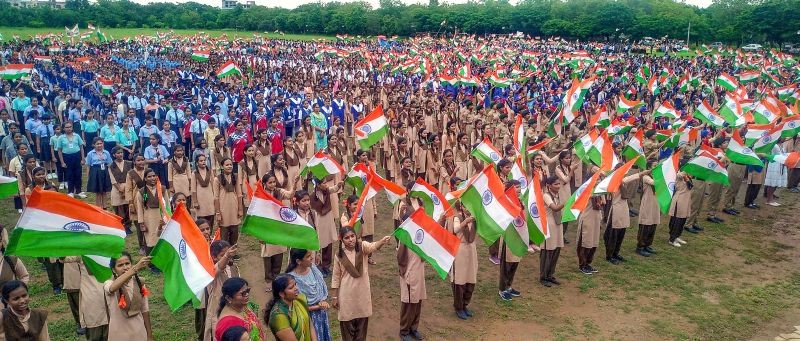 School students wave the national flags as they sing patriotic songs during a programme organised as part of 'Azadi Ka Amrit Mahotsav' celebrations, ahead of Independence Day, in Udaipur on August 12, 2022. (PTI Photo)