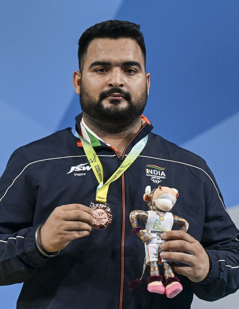 India's Lovepreet Singh poses for photos while standing at the podium after winning the bronze medal in the men's 109kg category weightlifting event at the Commonwealth Games 2022 (CWG), in Birmingham, UK on August 3, 2022. (PTI Photo)