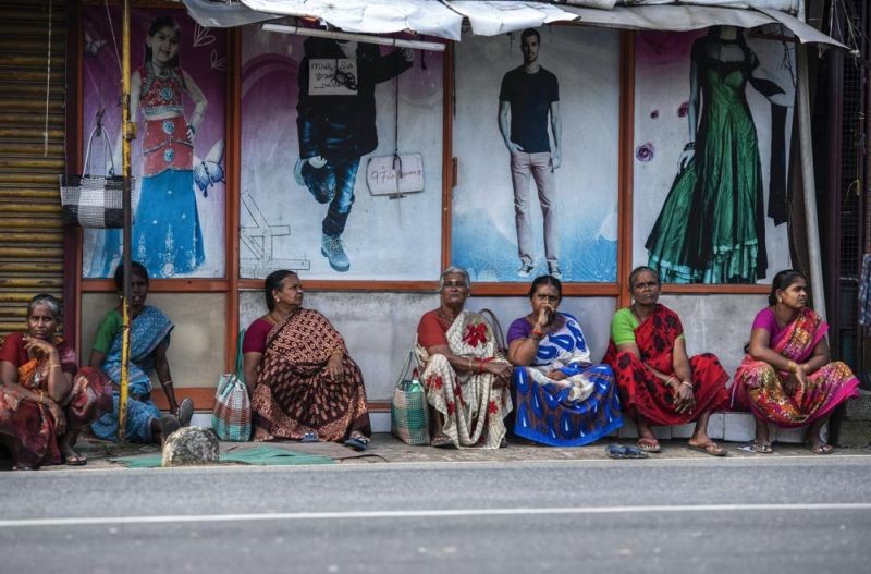 Tamil women sit by a roadside in the morning in anticipation of being hired for daily wage jobs in Kochi, southern Kerala state on August 10, 2022. Scenes like this are an everyday reality for millions of Indians, the most visible signs of economic distress in a country where raging unemployment is worsening insecurity and inequality between the rich and poor. (AP Photo)