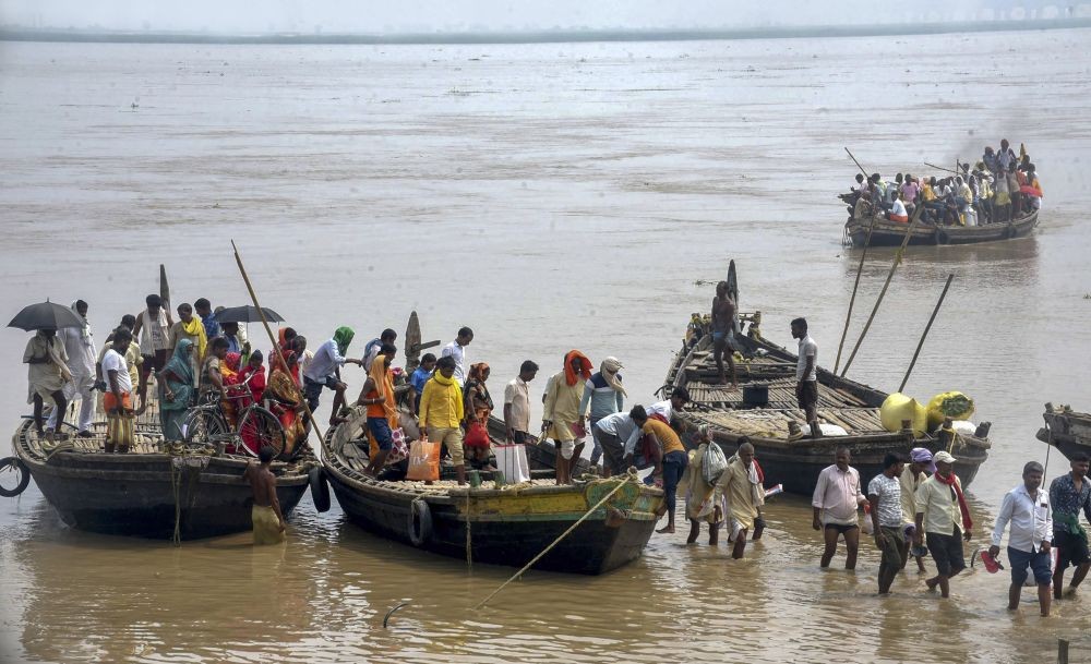 Patna: Villagers use boats to travel at a flood-affected area as the water level of the Ganga river continues stay high in the ongoing monsoon season, in Patna, Tuesday, Aug. 30, 2022. (PTI Photo)