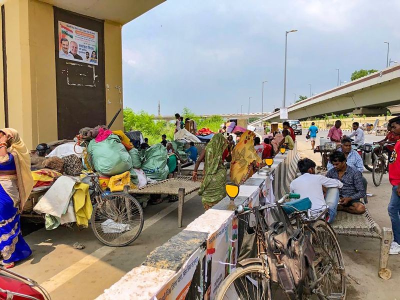 Locals with their belongings take sheltter on an elevated ground due to rise in the water level of Yamuna river, during the monsoon season in New Delhi on August 13, 2022. (PTI Photo)