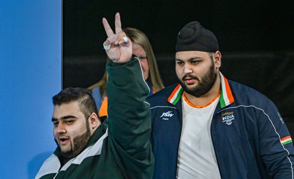 Birmingham: Bronze medal winner India's Gurdeep Sing with gold medal winner Pakistan's MND Butt flashes victory sign during the medal ceremony of men's weightlifting +109kg category event at the Commonwealth Games 2022 (CWG 2022), in Birmingham, UK, Wednesday, Aug 3, 2022. (PTI Photo/Swapan Mahapatra)