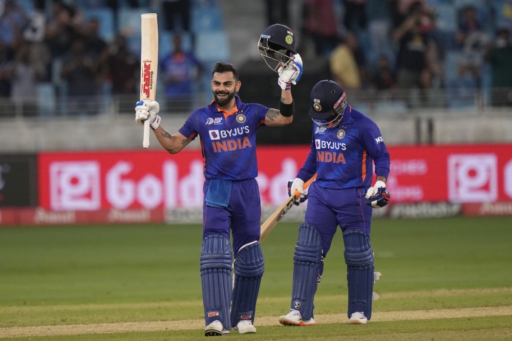 India's Virat Kohli, left, raises his bat and helmet to celebrate scoring a century during the T20 cricket match of Asia Cup between India and Afghanistan, in Dubai, United Arab Emirates, Thursday, Sept. 8, 2022. AP/PTI