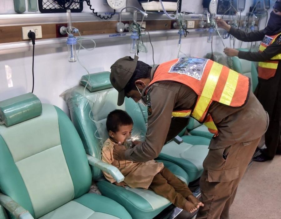 A rescuer gives medical treatment to a flood-affected child at a makeshift hospital in northwest Pakistan's Charsadda on Aug. 31, 2022. (Photo by Saeed Ahmad/Xinhua/IANS)