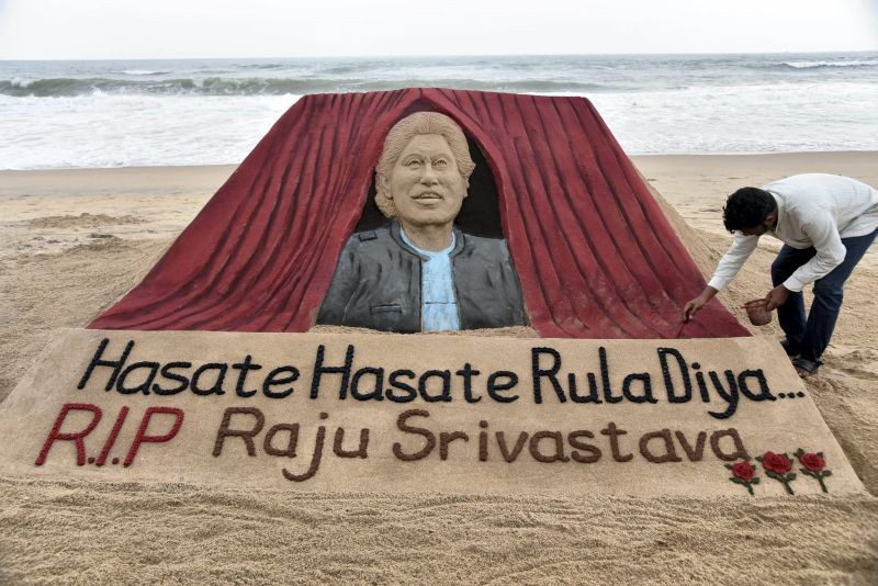Sand artist Sudarshan Pattanaik makes a sculpture to pay tribute to comedian Raju Srivastava, in Puri on September 21, 2022. Srivastava died on Wednesday at the age of 58 after more than 40 days in a Delhi hospital. (PTI Photo)