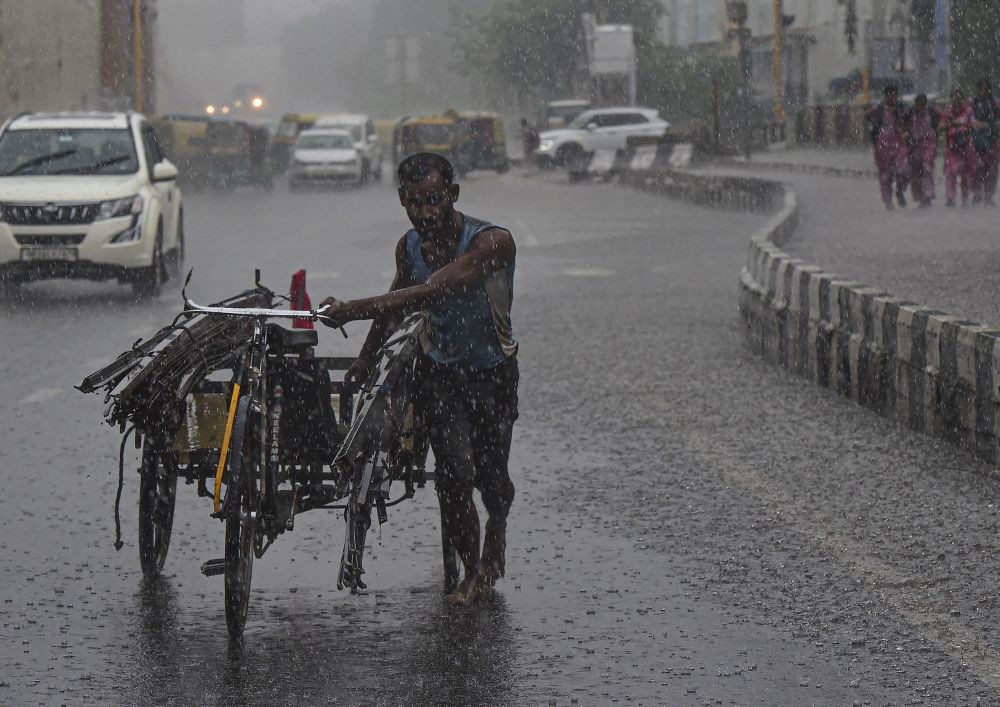 New Delhi: A worker pulls his tricycle cart during a sudden shower of monsoon rain, in New Delhi, Friday, Sept. 2, 2022. (PTI Photo/Kamal Kishore)