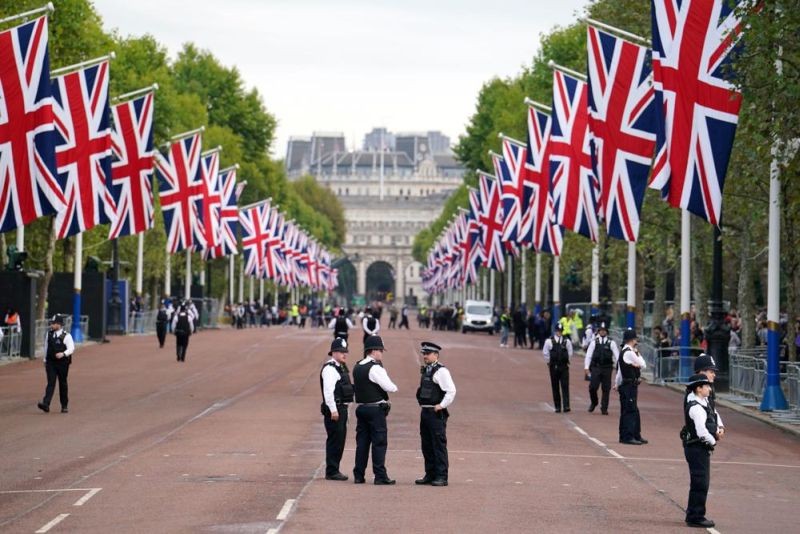 Police officers stand guard on The Mall ahead of the ceremonial procession of the coffin of Queen Elizabeth II, from Buckingham Palace to Westminster Hall, in London, Wednesday Sept. 14, 2022. The Queen will lie in state in Westminster Hall for four full days before her funeral on Monday Sept. 19. (AP Photo)