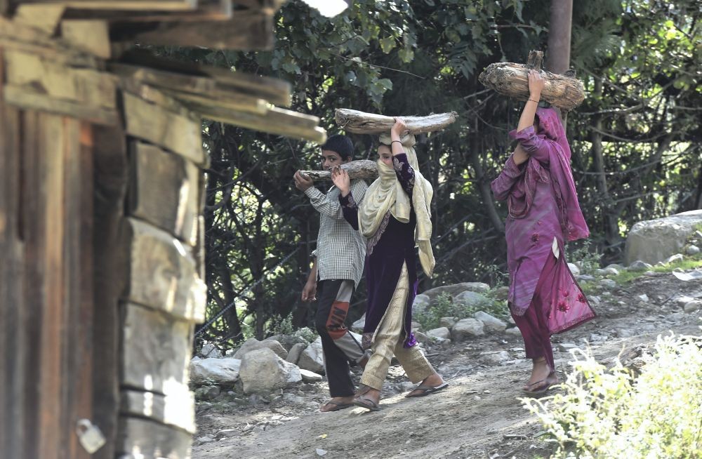 Keran: A family carrying fire wood walks to their home in the Keran sector of border district of Kupwara, north Kashmir, Wednesday, Aug. 31, 2022. Border residents are leading normal life following ceasefire agreement between India and Pakistan. Both Indian and Pakistan armies renewed the ceasefire agreement on the LoC in February last year and since then the villages across the LoC have witnessed peace. (PTI Photo/S. Irfan)