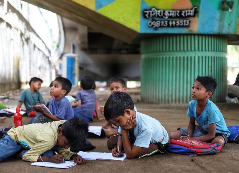 Children study in a makeshift school under a metro bridge on World Teachers' Day in New Delhi on Monday, Sept. 05, 2022. The free school underneath the metro bridge is run by teacher Rajesh Kumar and Laxmi Chandra for children who come from the slums situated adjacent to the Yamuna river. (IANS Photo)