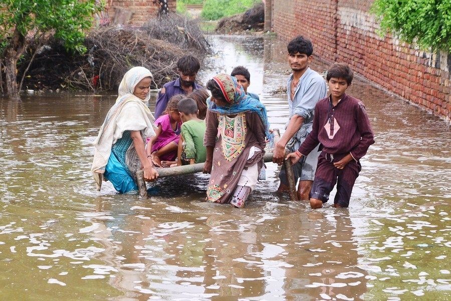 Flood-affected people evacuate from a flood-hit area in Tando Allahyar District in southern Pakistan's Sindh Province on Aug. 25, 2022. (Str/Xinhua/IANS)