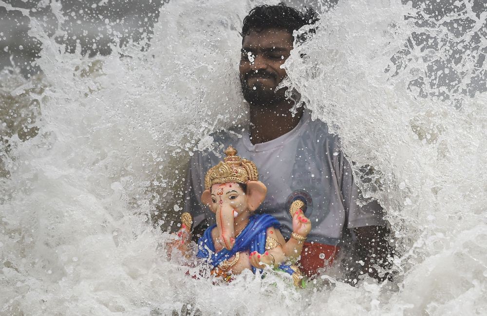 Mumbai: A devotee immerses an idol of Lord Ganesha during the ongoing Ganesh Chaturthi festival, in Mumbai, Sunday, Sept. 4, 2022.  (PTI Photo/Kunal Patil)