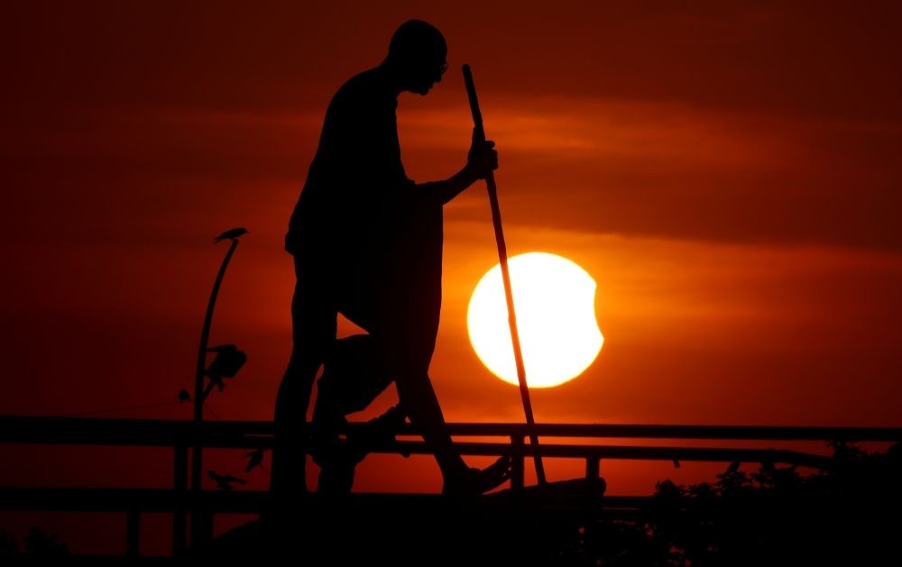Chennai:Statue of Mahatma Gandhi silhouetted against a partial solar eclipse in Chennai on Tuesday, Oct. 25, 2022.(Photo: R. Parthibhan/IANS)