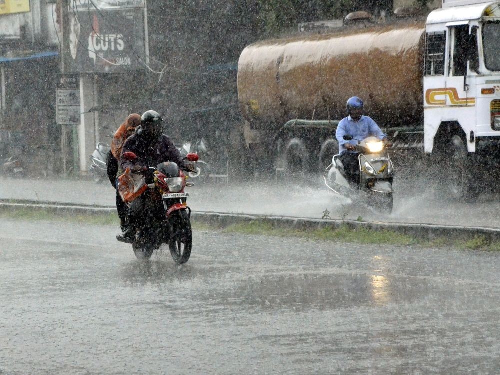 Nagpur: Commuters on two-wheelers make their way during heavy rain in Nagpur on Oct 10, 2022. (Photo: Chandrakant Paddhane/IANS)