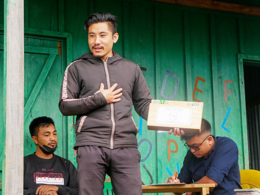 A member of the Nokhu Range Students’ Union explains the concept of ‘Pick Me Box’ initiative introduced by the union during its recent tours of schools under its jurisdiction. It is a free-will donation box to help those students who struggles to buy basic study materials. (Photo Courtesy: NRSU)