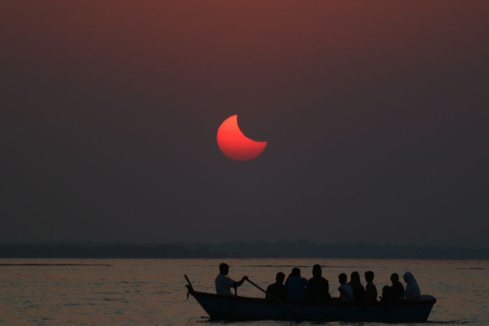Bhopal:A passenger boat silhouetted against a partial solar eclipse in Bhopal on, Tuesday, Oct. 25, 2022.(PHOTO:IANS/Hukum Verma)
