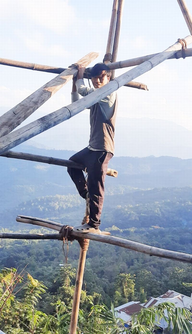 A construction worker stands on a bamboo scaffold without any safety harness or equipment, at a construction site in Mokokchung. The safety of construction workers remains a major concern for the workers in the state. (Morung Photo)