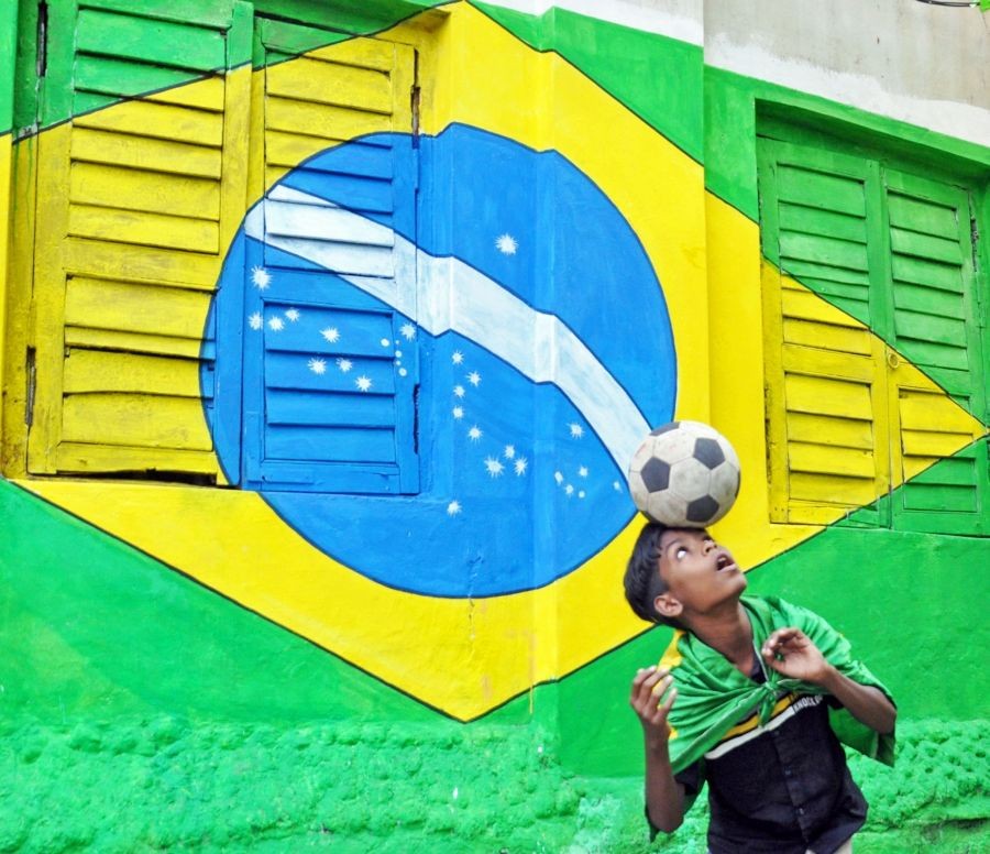 Kolkata: A boy shows his football skill in front of a graffiti of Brazilian flag on a wall to celebrate the FIFA World Cup 2022, in Kolkata on Nov 21, 2022. (Photo: Kuntal Chakrabarty/IANS)