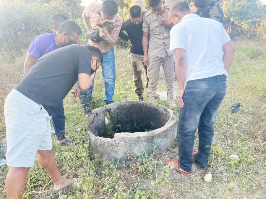 Onlookers and police personnel peering inside the well where the body of the deceased was found on November 26. (Morung Photo)