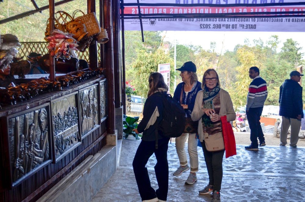 A tourist click pictures with young people dressed in their traditional attire on day two of the 23rd Hornbill Festival at the Naga Heritage Village, Kisama on December 2. (Morung Photo)