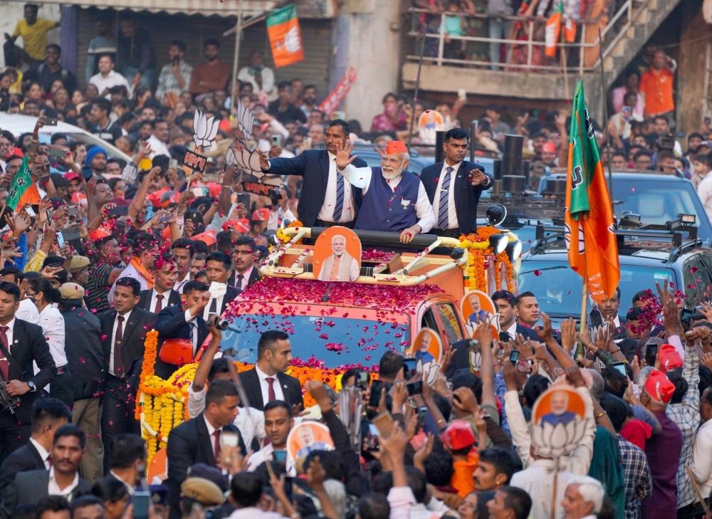 Ahmadabad :Prime Minister Narendra Modi waves to the supporters during the road show for upcoming Gujarat Assembly election in Ahmedabad, on Thursday, Dec. 01, 2022.(PHOTO:IANS/Siddharaj Solanki)