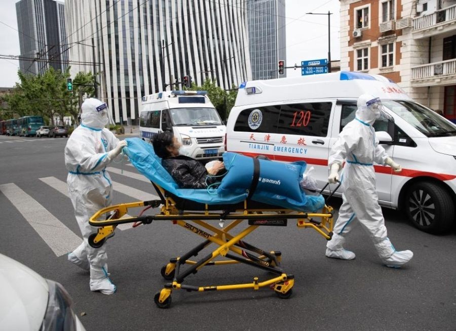 Meng Xiangjun and Zhang Zhimin transfer a COVID-19 patient in east China's Shanghai, May 9, 2022. (Xinhua/Jin Liwang)