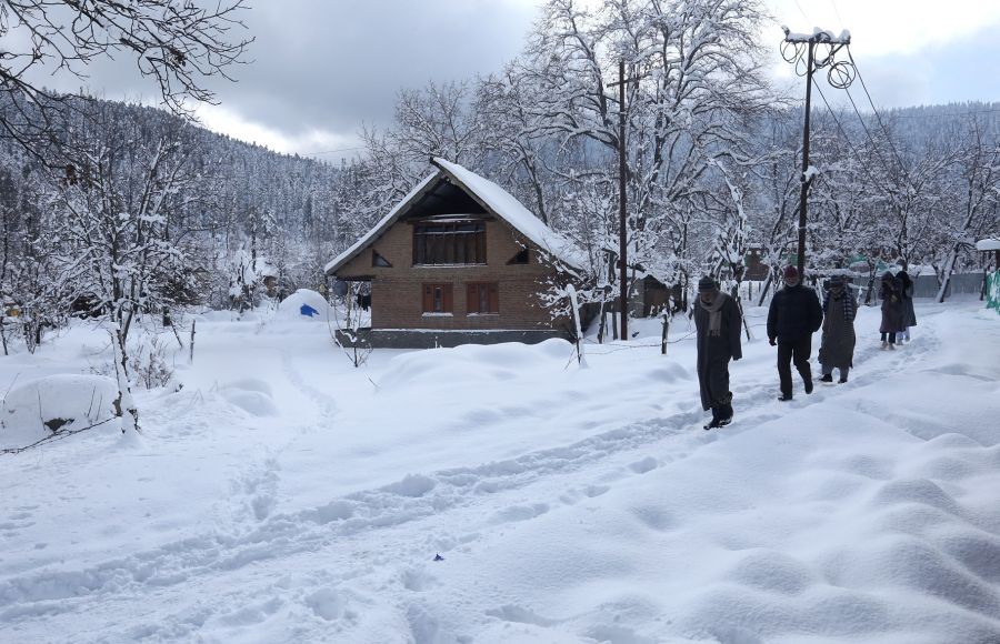 Budgam:People walk in the snow after heavy snowfall in Khaag of Budgam District on Saturday January 14,2023. Kashmir region received fresh snow on Friday, affecting air and vehicular traffic.(Photo: Nisar Malik /IANS)