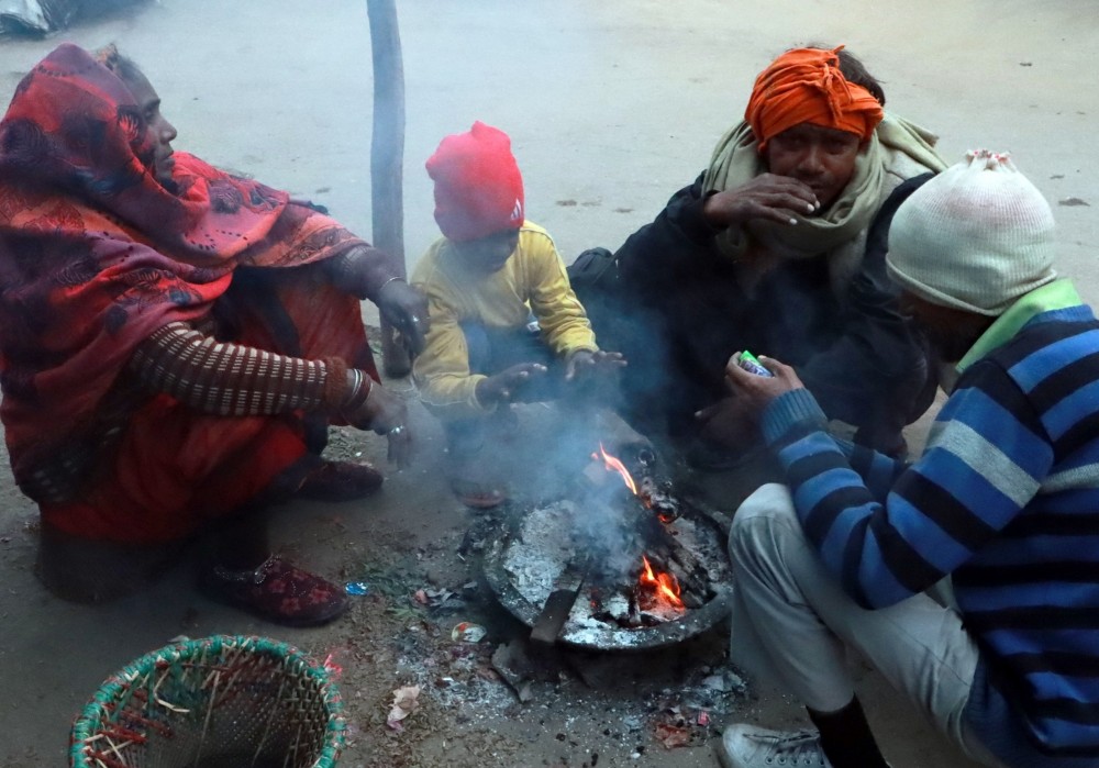 People keep themselves warm around a bonfire on a cold winter day, in New Delhi on January 4, 2023. (IANS Photo)