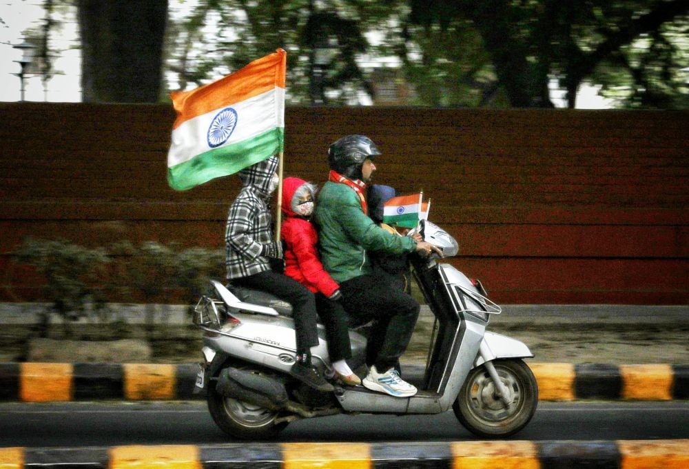 New Delhi: A child carrying the national flag on a two wheeler while going towards India Gate with family to celebrate Republic Day in New Delhi on Thursday January 26, 2023. (Photo: IANS/Wasim Sarvar)