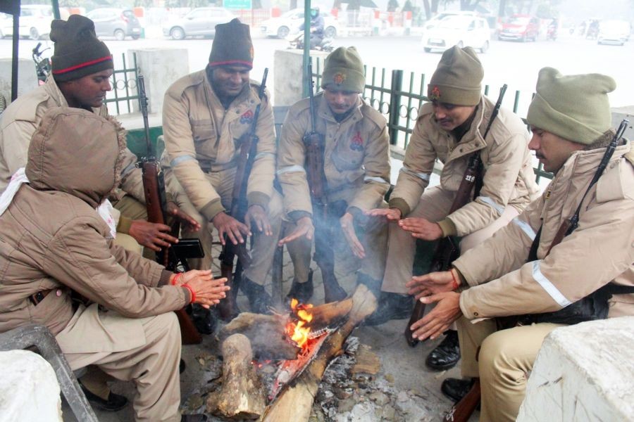 Meerut: Police personnel warm their hands around a bonfire on a cold day, in Meerut on Thursday, Jan. 05,  2023. (Photo: IANS)