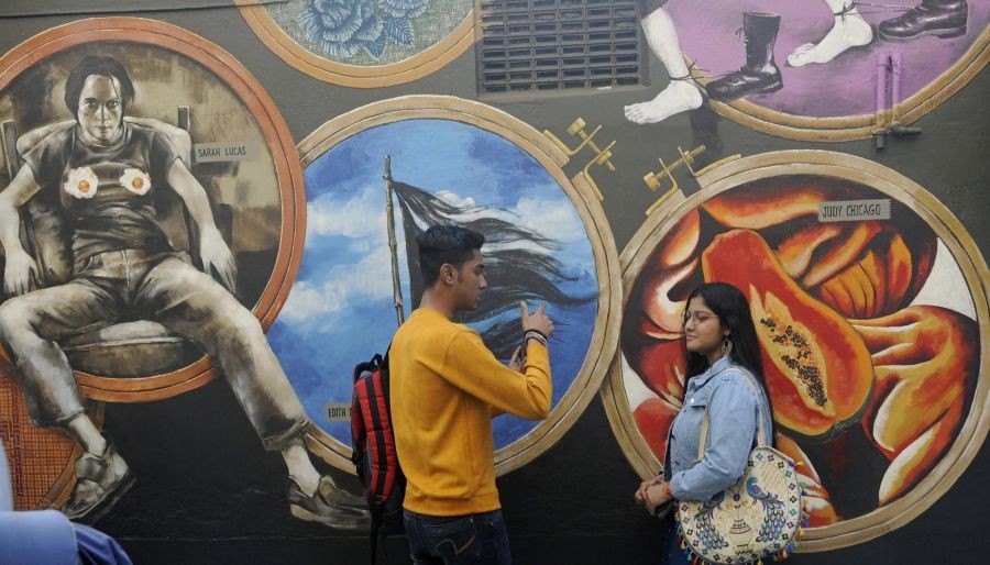 Kolkata:Couple take picture in front of a painted wall for Behala Art Festival in Kolkata on Saturday February 04,2023.(Photo: Kuntal Chakrabarty/IANS)