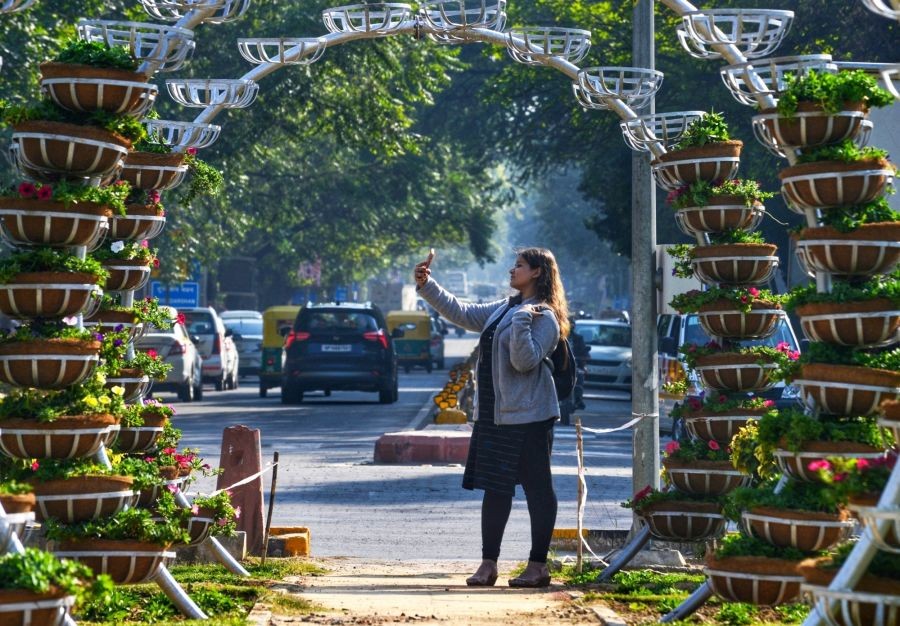 New Delhi: A woman taking a selfie with flowers decorated by NDMC near Mandi House in New Delhi on Saturday, Feb 04, 2023.. (Photo: IANS/Wasim Sarvar)