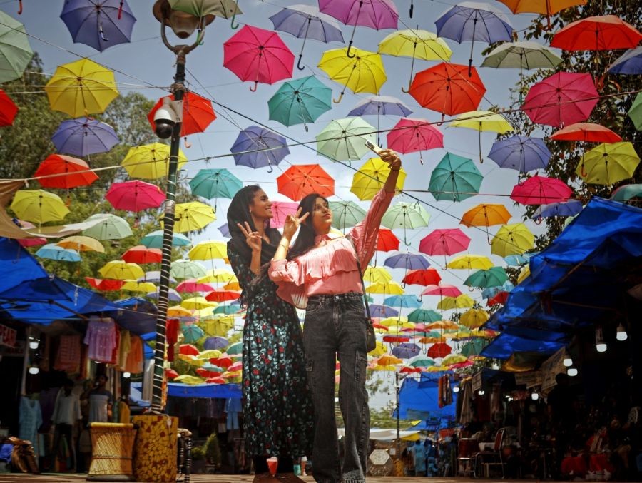 New Delhi: A girl takes a selfie as umbrellas are hung at Dilli Haat to beat the heat , in New Delhi on Tuesday, April 18, 2023. (Photo: Wasim Sarvar/IANS)