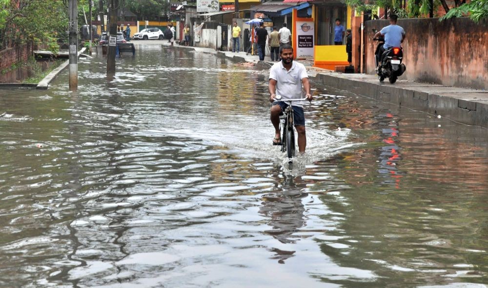 Guwahati :A man on a bicycle wades through a water-logged road after heavy rainfall in Guwahati on Sunday, April 23, 2023. (Photo:IANS/Anuwar Hazarika)