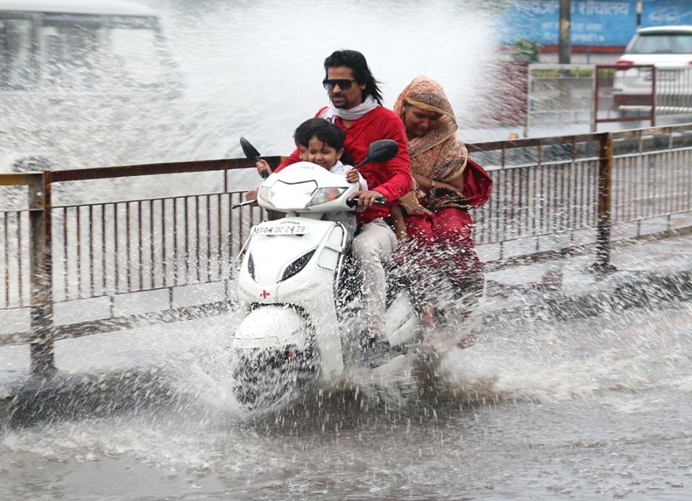 Bhopal: A man rides his two-wheeler during heavy rain, in Bhopal on Sunday, April 30, 2023 (Photo:IANS/Hukum Verma)