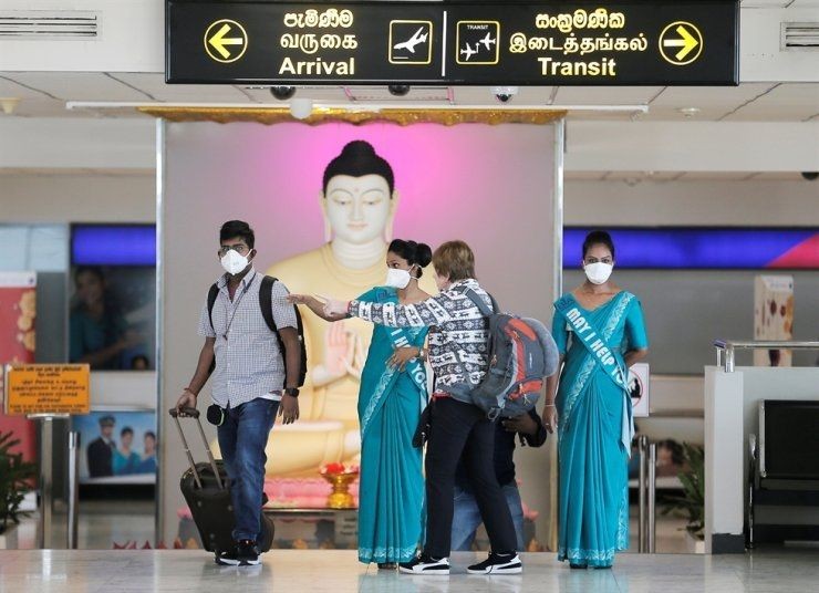 Seoul :Bandaranaike international airport officials wears masks as they direct tourists after they went through a temperature scanner at Bandaranaike international airport in Katunayake, Sri Lanka, Jan. 24, 2020.(Yonhap/IANS)