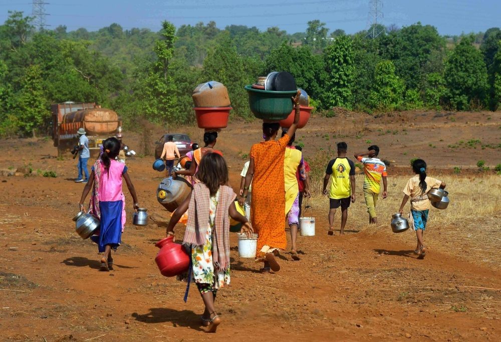 Thane : Villagers walk towards the water tanker to collect water in Shahapur Taluka, Thane District, on Sunday, May 21, 2023. (Photo: Nitin Lawate/IANS)