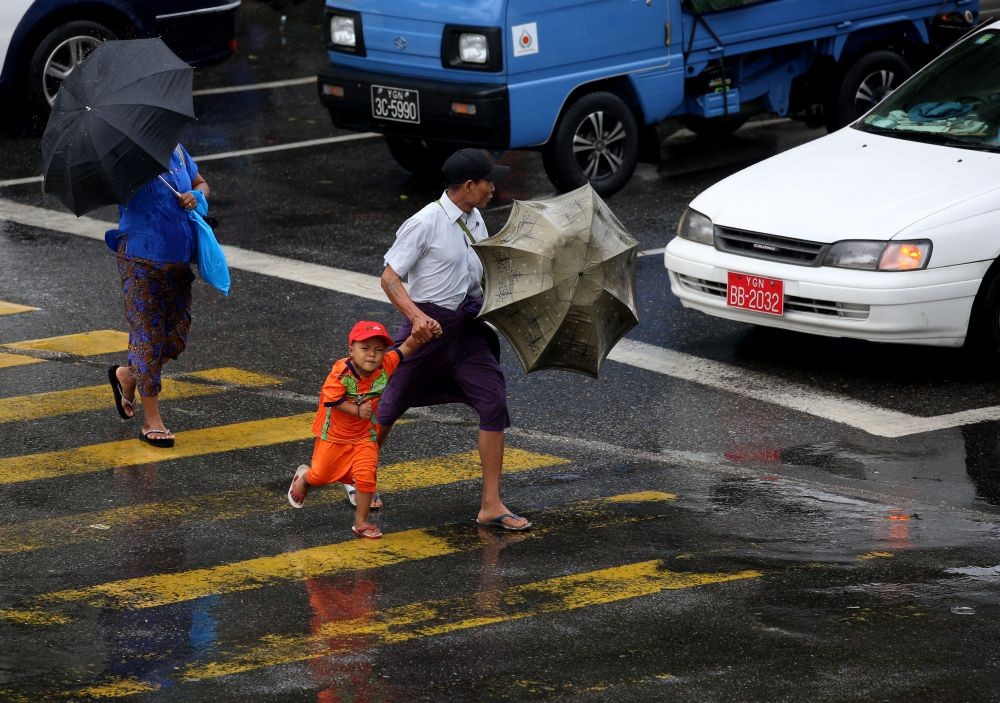 YANGON, May 29, 2018 (Xinhua) -- People walk across the road in Yangon, Myanmar, May 29, 2018. Myanmar's Meteorology and Hydrology Department issued a red-code emergency alert warning Tuesday that a deep depression is occurring over middle-east part of the  Bay of Bengal and the cyclone storm will land in  coastal areas of Rakhine state within the next 12 hours. (Xinhua/U Aung) (dtf)