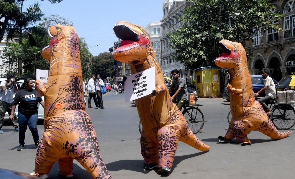 Mumbai: Volunteers from People for the Ethical Treatment of Animals (PETA) dressed as dinosaurs, made an appeal to the upcoming G20 working group to embrace veganism, at Horniman Circle in Mumbai on Friday, May 19, 2023.(Photo: IANS)